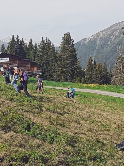 Eine Gruppe geht die Wiese auf dem Rinerhorn hinauf und sammelt den Abfall ein.  | © Davos Klosters Mountains