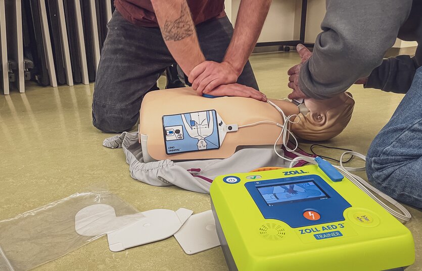 Männliche Person führt Herzdruckmassage an Dummy aus.  | © Davos Klosters Mountains 