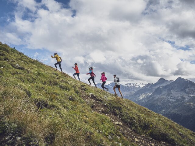 In einer Linie laufen die fünf Trailrunner den Hang des Jakobshorns hinauf.  | © Davos Klosters Mountains