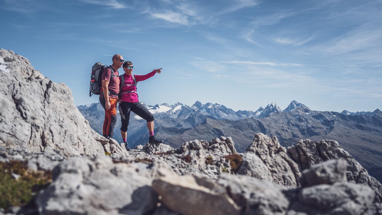 Zwei Wanderer stehen auf dem Weissfluhgipfel, die Frau zeigt auf den Horizont. | © Davos Klosters Mountains