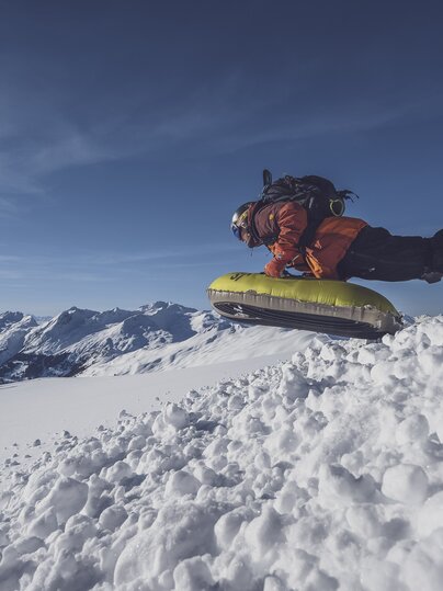 Mit einem Sprung startet ein Gast die Abfahrt über die verschneiten Hänge auf Pischa. | © Davos Klosters Mountains