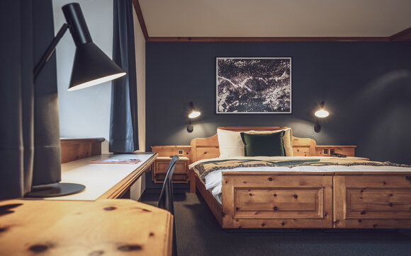 Doppelbettzimmer mit Bettwäsche und Nachttischlampe | © Davos Klosters Mountains 
